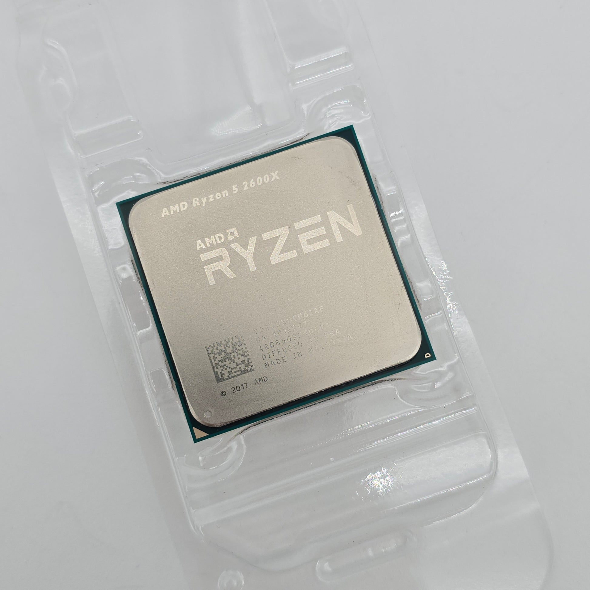 AMD Ryzen CPU in clear packaging on a light gray background