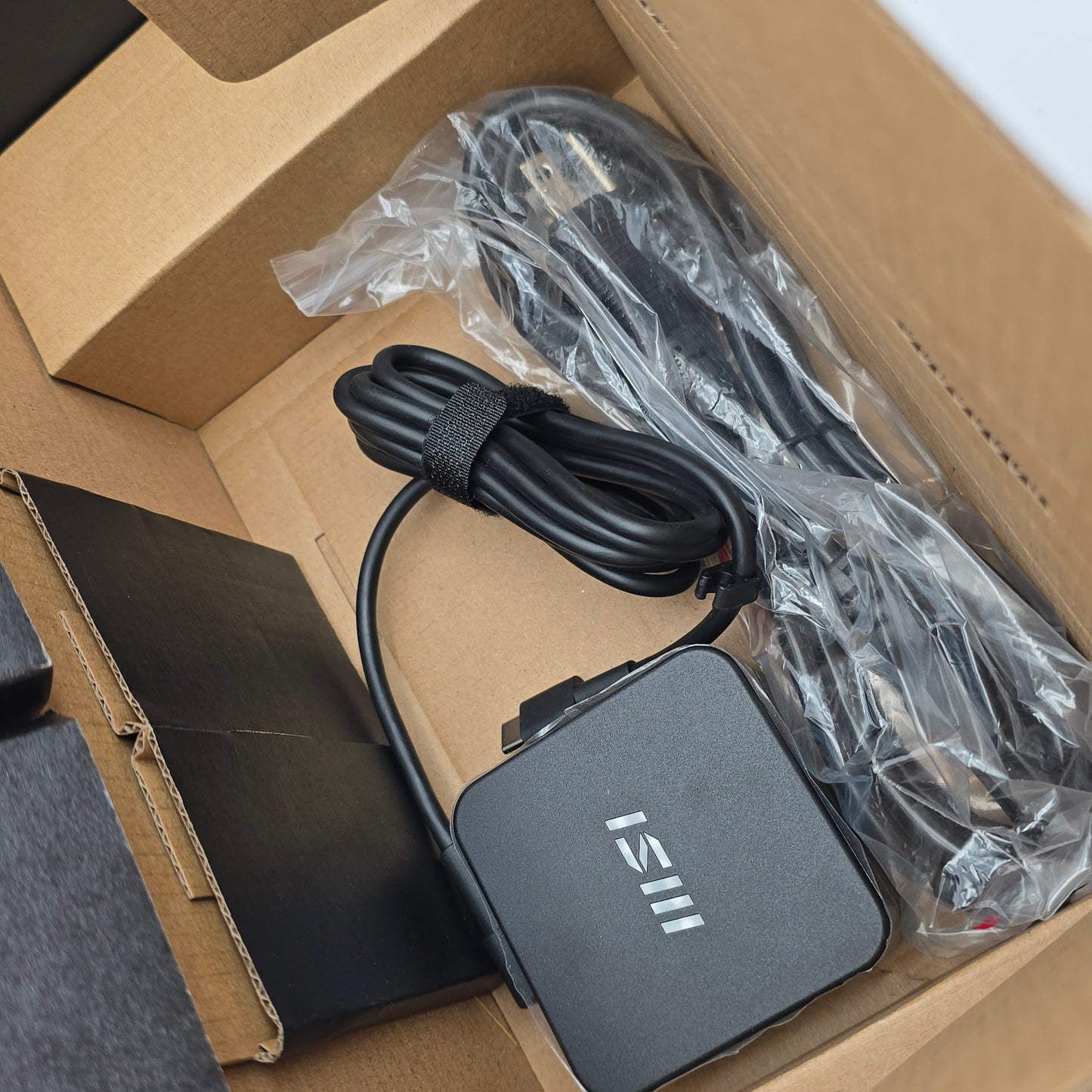 ISIII power adapter and cable inside a cardboard box