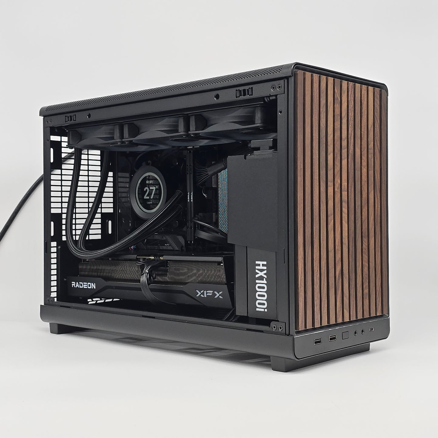 Computer case with wooden side panel on a white background, case is a lian li dan a3 wood, gpu is an xfx 9070 xt 16gb, has a kraken z73 nzxt liquid cooler, micro atx form factor
