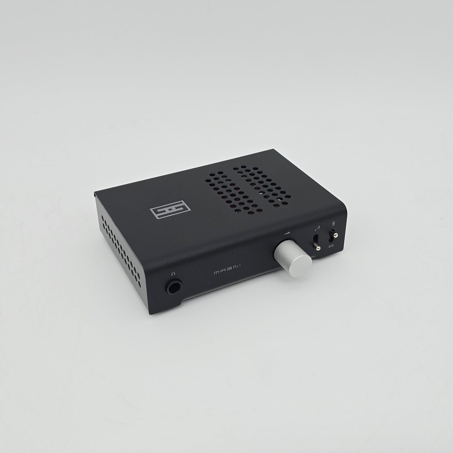 Black audio interface with a white knob on a light gray background