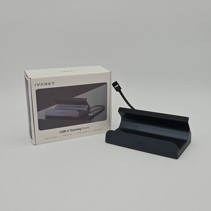 Black USB-C gaming dock with packaging on a gray background