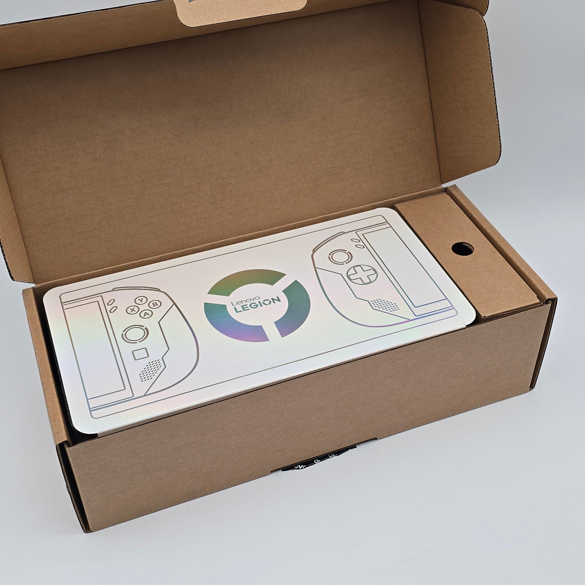 Open cardboard box with a printed design of a gaming controller and 'Legion' logo on a white background.