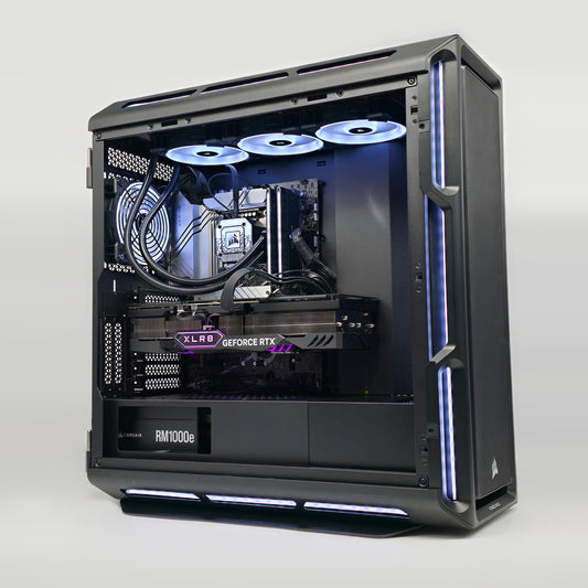 Open computer case with visible hardware components on a white background, showing a 4090 graphics card, corsair dominator titanium ram and a high end motherboard