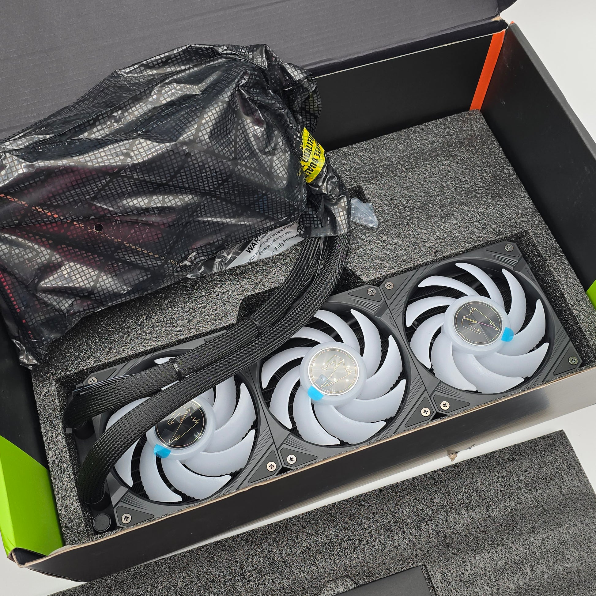 Computer cooling system with fans in a box, surrounded by packaging materials.