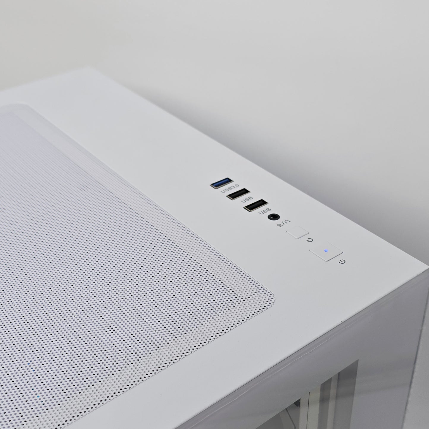Close-up of a white electronic device with control buttons on a light gray background