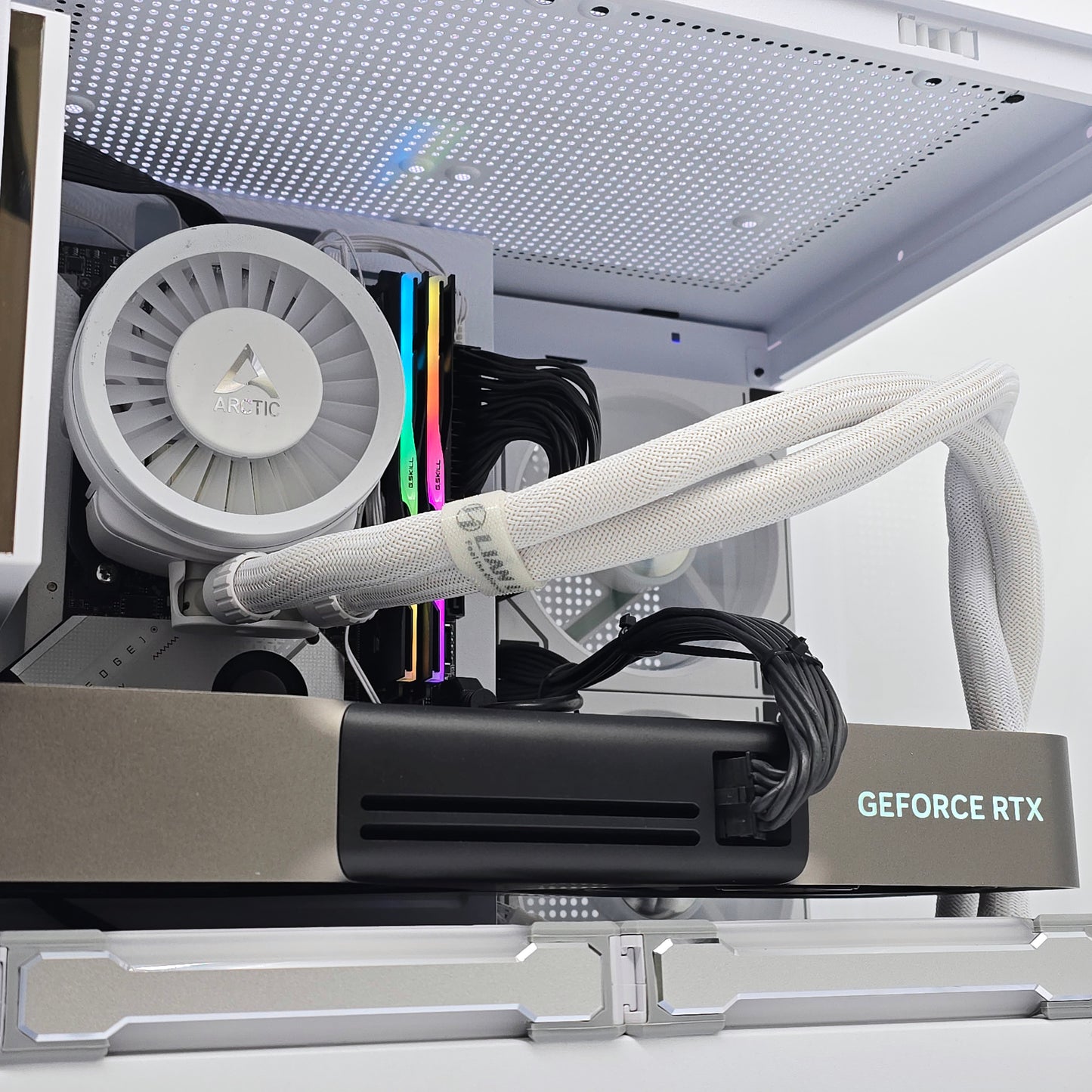 Close-up of a computer graphics card with a white radiator and visible brand name.