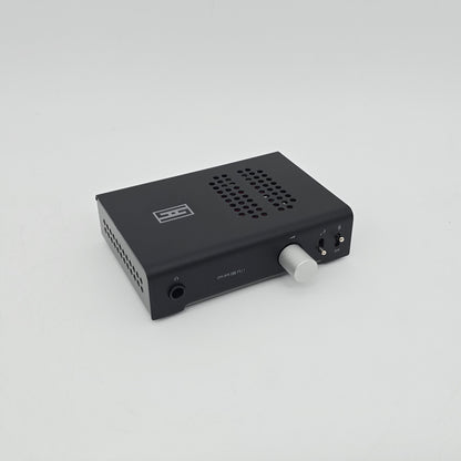 Black audio interface with a white knob on a light gray background