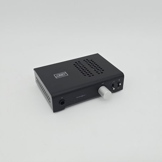 Black audio interface with a white knob on a light gray background